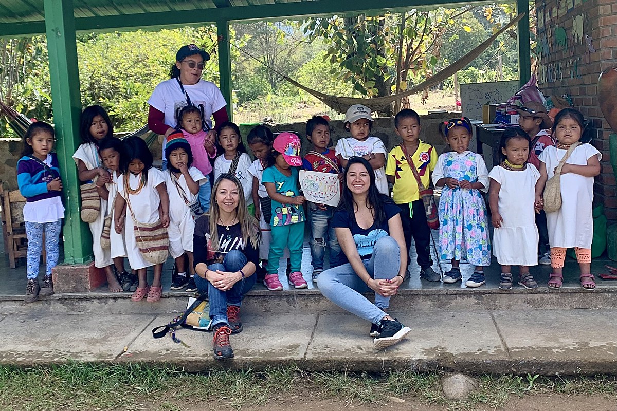 Equipo de Zolem con los niños de la comunidad arhuaca de Nabusimake frente al Hogar Sirena, uno de ellos sosteniendo un dibujo en forma de corazón con el nombre Zolem