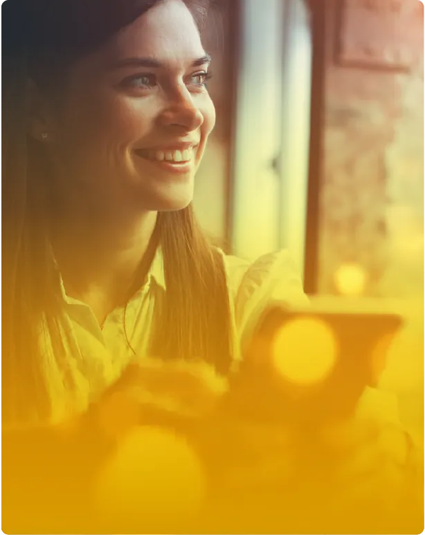 Mujer sonriendo mirando por una ventana con luz cálida, experiencia de potencial, propósito y cultura en la ruta de liderazgo y desarrollo humano de Zolem